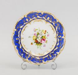 Тарелка с синим крытьем и букетом цветов на зеркале.
