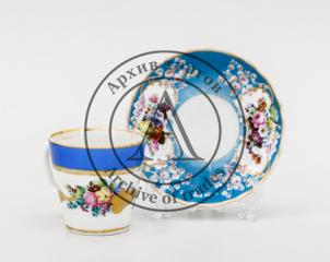Кофейная пара (в подборе): чашка с синим крытьем и росписью цветами с золотыми листьями, блюдце с голубым крытьем и росписью цветами в резервах.
