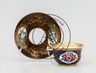 Чайная пара в подборе: чашка с кобальтовым крытем и блюдце с коричневым крытьем и цветами в резервах.