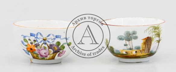 Две чайные чашки с изображением пейзажа и корзины с цветами